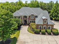 Stately brick home featuring manicured landscaping and mature trees providing shade and privacy at 55 Moray Pl, Covington, GA 30014