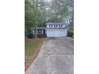Charming two-story home featuring a two-car garage and inviting front porch in a wooded setting at 2857 Mountbery Dr, Snellville, GA 30039