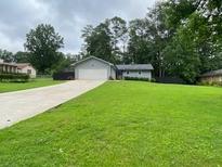 Well maintained home on large lot with a sprawling green lawn and an extended concrete driveway at 284 Regal Dr, Lawrenceville, GA 30046