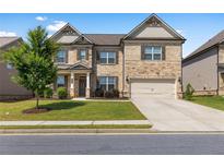Charming two-story home with a well-manicured lawn, stone accents, and an attached two-car garage at 3717 Blue Goose Ln, Loganville, GA 30052