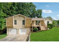 Charming two-story home with a two-car garage, a welcoming front porch, and a beautifully landscaped front yard at 3753 Eli Dr, Snellville, GA 30039