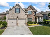 Charming brick and stone home featuring a two-car garage and well-manicured lawn at 3952 Dragon Fly Ln, Loganville, GA 30052