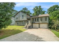 Charming two-story home featuring an attached two-car garage and lush landscaping at 1105 Tom Lane Ln, Marietta, GA 30066