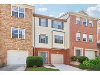 Attractive townhome featuring a brick and siding exterior with blue shutters and a one-car garage at 528 Lantern Wood Dr, Scottdale, GA 30079