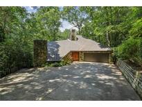 Unique home exterior with stone accents, skylight, mature trees, and attached garage at 562 Pine Valley Se Rd, Marietta, GA 30067