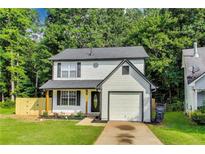 Charming two-story home featuring a well-manicured lawn, single car garage, and fresh landscaping at 131 Turning Point, Stockbridge, GA 30281