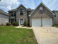 Charming two-story brick home with a well-manicured lawn, a two-car garage and a welcoming front entrance at 3850 Micah Ln, Ellenwood, GA 30294