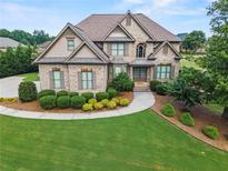 Beautiful brick home with manicured lawn, mature trees, and meticulous landscaping at 2602 Alcovy Club Dr, Dacula, GA 30019