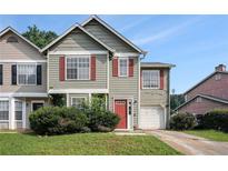 Inviting two-story townhouse featuring red shutters, a red door, and a one-car garage at 3835 Conley Downs Dr, Decatur, GA 30034