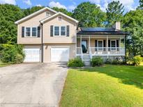Charming home with a front porch, well-maintained lawn and two-car garage at 443 Rhett Dr, Loganville, GA 30052