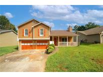 Charming two-story home featuring a covered front porch, two-car garage and a well-maintained lawn at 2397 Planters Cove Dr, Lawrenceville, GA 30044