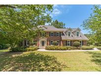 Charming two-story brick home with mature trees and manicured landscaping at 4989 Woodfall Sw Dr, Lilburn, GA 30047
