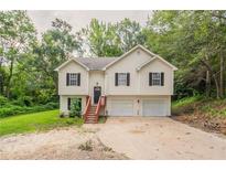 Charming two-story home featuring a two-car garage and a welcoming entrance with wooden stairs at 5069 Jonesboro Rd, Union City, GA 30291