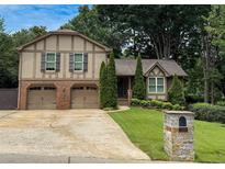Charming home featuring a brick and siding exterior, attached two-car garage, and well-manicured lawn at 1280 Sanden Ferry Dr, Decatur, GA 30033