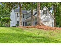 Traditional two-story home with light blue siding, black shutters, and a well-manicured lawn at 1420 Fieldgreen Overlook, Stone Mountain, GA 30088