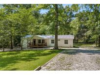 Charming single-story home with a welcoming front porch and lush green surroundings at 5711 Hill View Dr, Oxford, GA 30054