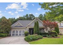 Charming home featuring a well-manicured lawn, a two-car garage, and beautiful landscaping at 308 Shade Tree Cir, Woodstock, GA 30188