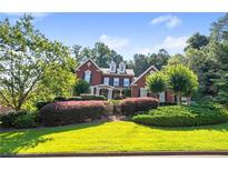 Charming two-story brick home with manicured landscaping and a welcoming front yard at 5410 Cottage Farm Rd, Alpharetta, GA 30022