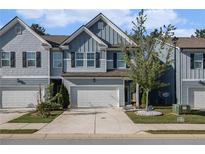 Charming townhome with a blue exterior, two-car garage, and well-manicured front yard at 7086 Gladstone Cir, Lithonia, GA 30038