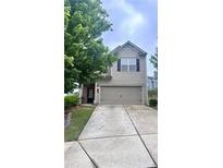 Charming two-story home featuring a spacious driveway and an attached garage for convenient parking at 1403 Comet Ives Ln, Lawrenceville, GA 30045