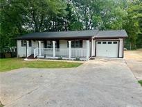 Inviting single-story home with a classic porch and convenient attached one car garage at 256 New Hope Rd, Lawrenceville, GA 30046