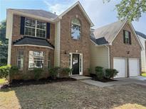 Charming two-story brick home with well-manicured lawn and attached two-car garage at 4189 Post Oak Grv, Atlanta, GA 30349