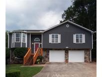Charming two-story home featuring gray siding, stone accents, wood stairs, and a well-maintained front yard at 2333 Wilkins Cv, Decatur, GA 30035