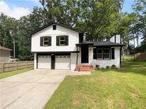Charming two-story home with a well-manicured lawn and two-car garage offering curb appeal at 3867 Cherie Glen Rd, Snellville, GA 30039