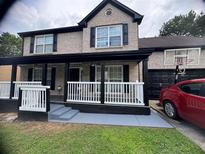 Charming brick two-story home featuring a welcoming front porch and attached garage at 595 Castlebrooke Dr, Lawrenceville, GA 30045