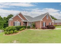 Charming brick home with manicured lawn, complemented by verdant shrubbery and mulch beds at 995 Lewis Ridge Cir, Lawrenceville, GA 30045
