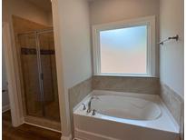 Modern bathroom features a soaking tub with tile surround and separate glass shower at 5311 Tuscany Dr, Douglasville, GA 30135