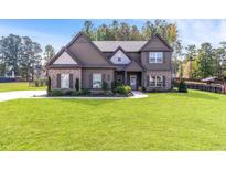 Beautiful two-story home featuring a well-manicured lawn and complementary brick and siding accents at 125 Atkins Ln, Fayetteville, GA 30215
