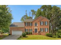 Charming two-story brick home with manicured lawn and attached two car garage at 140 Heritage Ct, Fayetteville, GA 30214