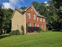 Charming two-story home featuring a brick facade and lush green lawn at 2209 Willow Crest Cir, Lawrenceville, GA 30044
