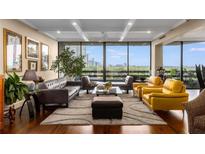 Bright living room featuring hardwood floors, multiple seating areas, and expansive windows with city views at 2660 Peachtree Nw Rd # 13F, Atlanta, GA 30305