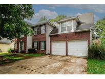 Charming two-story brick home with a spacious driveway and attached two-car garage at 1964 Cutters Mill Way, Lithonia, GA 30058