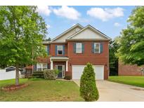 Charming two-story brick home with a well-manicured lawn and two-car garage at 12148 Flannery Ln, Hampton, GA 30228