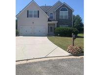 Charming two-story home featuring a two-car garage, neutral siding and a well-manicured lawn at 2118 Water Mill Ct, Buford, GA 30519