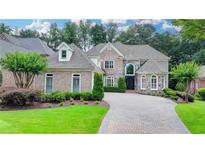 Stunning brick home with manicured landscaping and a beautiful stone driveway at 8230 Royal Melbourne Way, Duluth, GA 30097
