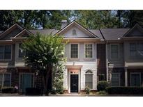 Charming townhome with manicured landscaping and a welcoming front entrance with sidelight windows at 1282 Harris Commons Pl, Roswell, GA 30076