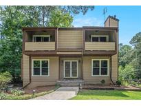 Charming two-story home featuring a covered entry and twin balconies with verdant lawn and mature tree surround at 3611 Winfair Pl, Marietta, GA 30062