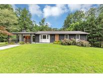 Charming, renovated ranch-style home with a manicured lawn, stylish black brick, and a delightful splash of color on the front door at 851 Flagler Se Cir, Smyrna, GA 30080