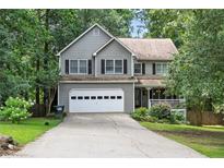 Traditional two-story home with a two-car garage, mature trees and an inviting front porch at 131 Banyon Ct, Dallas, GA 30157