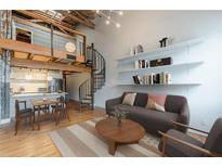 Stylish living room with hardwood floors, spiral staircase, and open shelving above a comfortable gray couch at 63 Mangum Sw St # 3, Atlanta, GA 30313