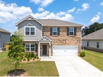 Charming two-story brick home with a well-manicured front yard and attached two-car garage at 3660 Cattle Field Xing, Loganville, GA 30052