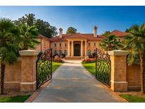 Grand estate entrance featuring ornate iron gates, manicured lawns, and stately architecture at 720 Heards Ferry Rd, Sandy Springs, GA 30328