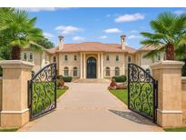 Stunning Mediterranean-style home featuring a gated entrance, lush landscaping, and a grand facade at 720 Heards Ferry Rd, Sandy Springs, GA 30328