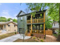 Charming two-story home with double front porches, green siding and an attached garage at 224 Cambridge Avenue, Decatur, GA 30030