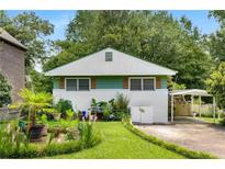 Charming cottage-style home with a well-manicured front yard, plants, and a carport at 2355 Ewing Ne Dr, Brookhaven, GA 30319