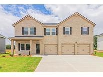 Charming two-story home with a three-car garage and a manicured lawn at 1662 Fuma Leaf Way, Mcdonough, GA 30252